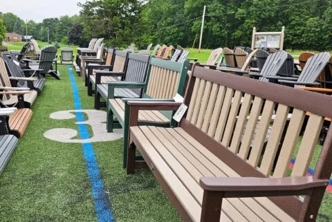 Poly benches and chairs set out on green turf