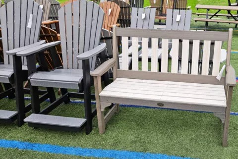 Gray Adirondack chairs next to a matching bench